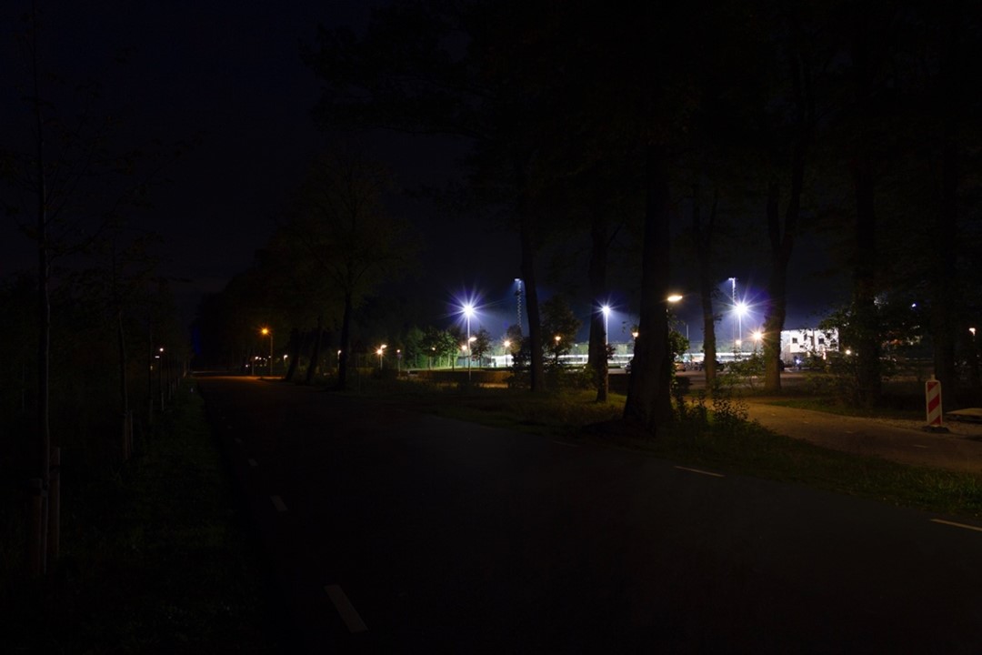 Donkere omgeving met in de verte felle verlichting. Zie bijschrift onder afbeelding